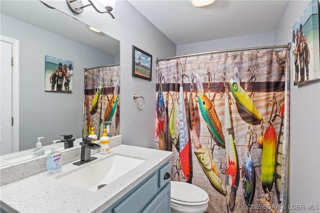 bathroom featuring curtained shower, toilet, and vanity