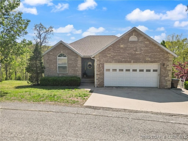 ranch-style house with a garage, brick siding, a front lawn, and concrete driveway
