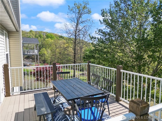 63 Lancelot Ct, Camdenton, MO 65020 - deck with outdoor dining area and a wooded view