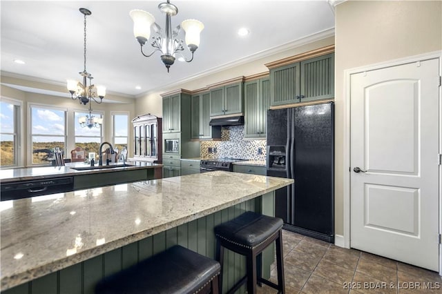 kitchen with a sink, a chandelier, green cabinets, under cabinet range hood, and black appliances