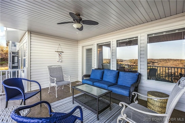 wooden deck with outdoor lounge area and ceiling fan