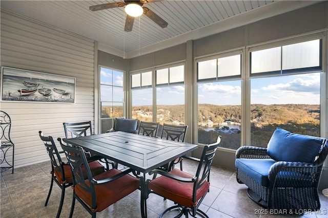 sunroom with a ceiling fan and outdoor dining space