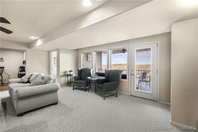 carpeted living room featuring ceiling fan and baseboards