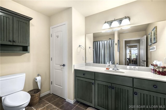 bathroom featuring tile patterned floors, vanity, toilet, and baseboards