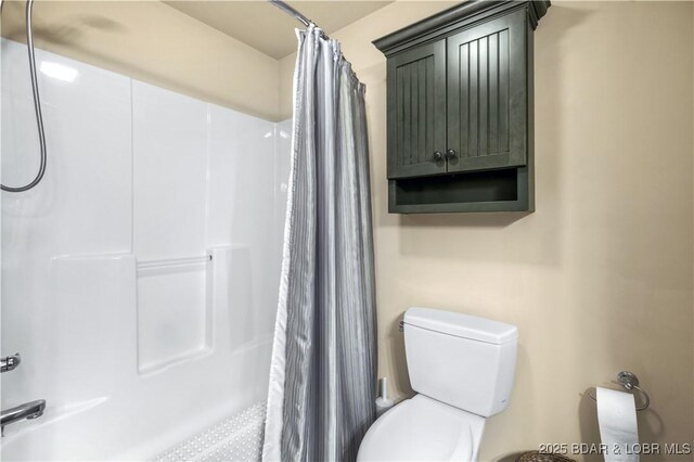 bathroom featuring a shower with curtain and toilet