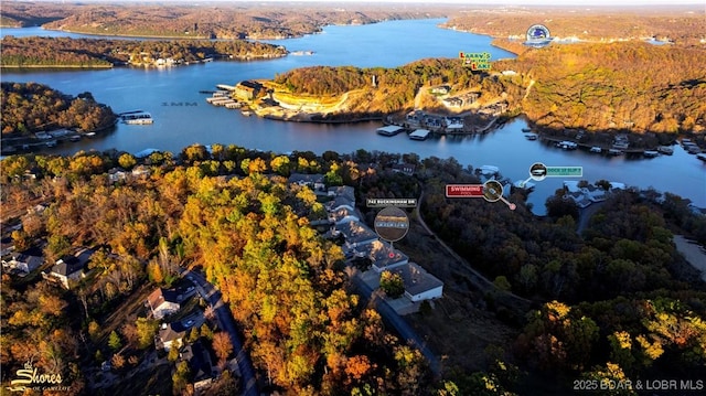 aerial view featuring a wooded view and a water view