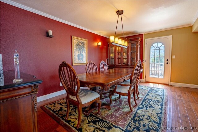 4956 Shorewood Dr, Osage Beach, MO 65065 - dining space with baseboards, ornamental molding, an inviting chandelier, and wood-type flooring