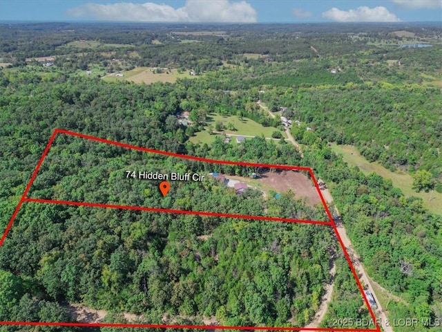 bird's eye view with a wooded view