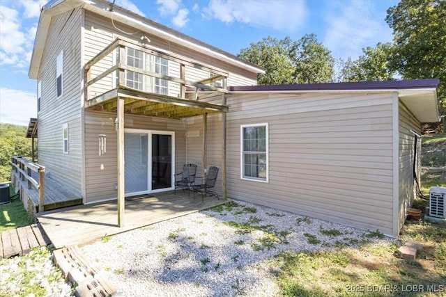 back of property featuring a patio, a wooden deck, and cooling unit