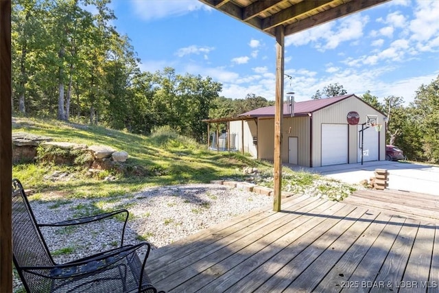wooden deck featuring a garage and an outbuilding