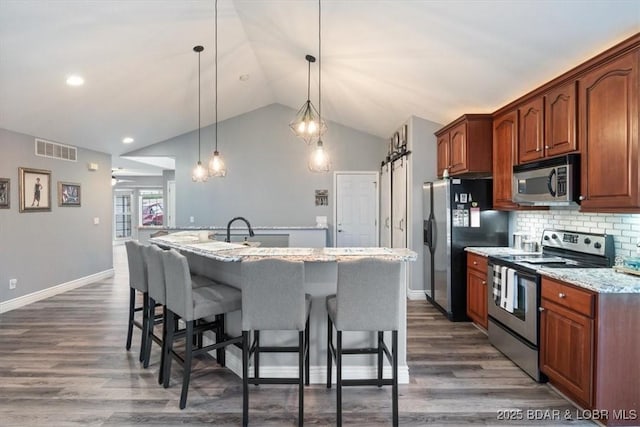 5177 Vicus Castry, Osage Beach, MO 65065 - kitchen featuring an island with sink, a breakfast bar, dark wood-type flooring, visible vents, and appliances with stainless steel finishes