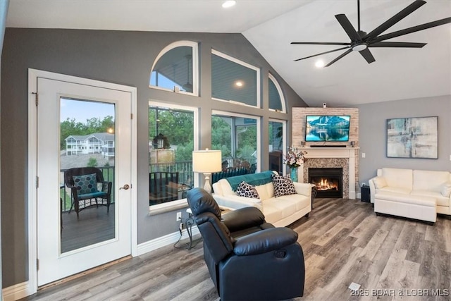 5177 Vicus Castry, Osage Beach, MO 65065 - living area featuring wood finished floors, a ceiling fan, high vaulted ceiling, a lit fireplace, and baseboards