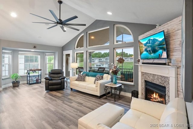 5177 Vicus Castry, Osage Beach, MO 65065 - living room with wood finished floors, high vaulted ceiling, baseboards, ceiling fan, and a warm lit fireplace