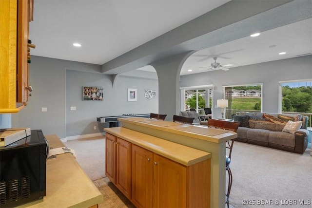 5177 Vicus Castry, Osage Beach, MO 65065 - kitchen with ceiling fan, light colored carpet, light countertops, a kitchen island, and recessed lighting