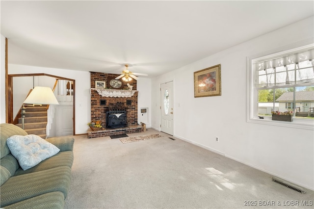 9 Gage Rd, Eldon, MO 65026 - carpeted living area with a wood stove, stairway, visible vents, ceiling fan, and baseboards