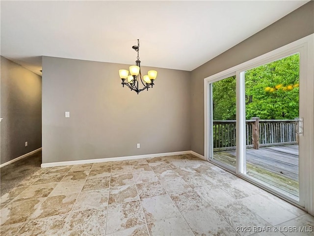 empty room featuring visible vents, a chandelier, stone tile flooring, and baseboards
