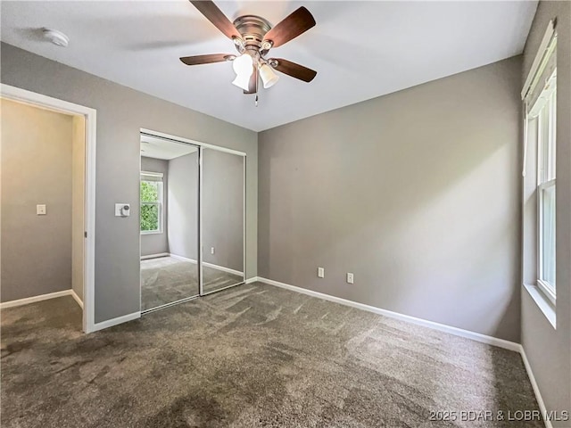 unfurnished bedroom with baseboards, ceiling fan, a closet, and carpet flooring