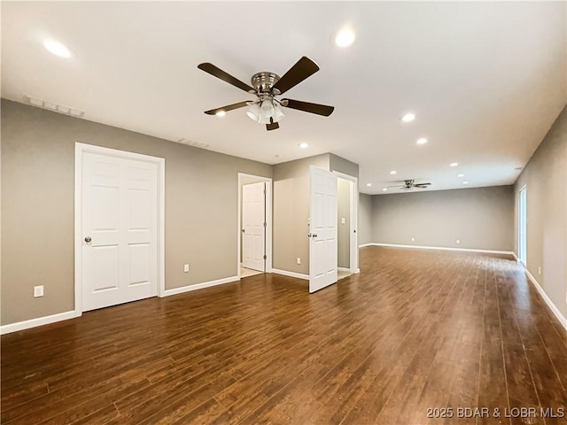 spare room featuring a ceiling fan, visible vents, baseboards, and dark wood-type flooring