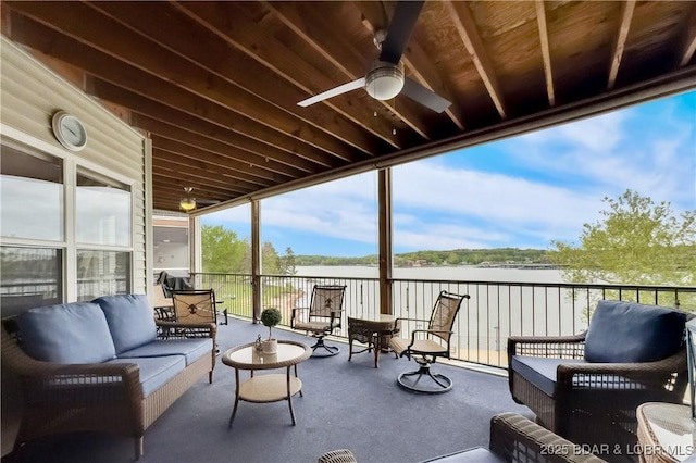 sunroom / solarium featuring an outdoor living space, a ceiling fan, and a water view