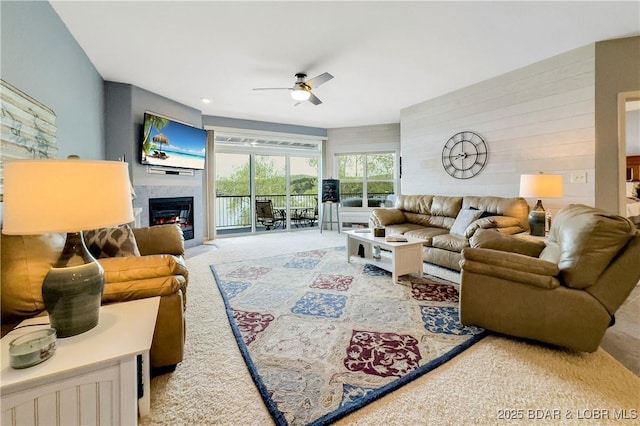 carpeted living area featuring ceiling fan and a glass covered fireplace