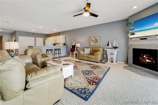 living area featuring recessed lighting, a fireplace, a ceiling fan, carpet, and baseboards