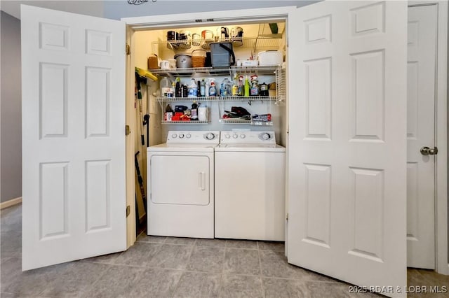 clothes washing area with light tile patterned floors, washer and dryer, and laundry area