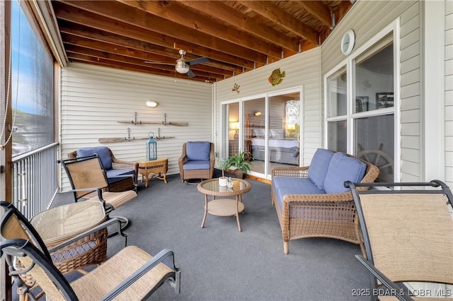 sunroom featuring a ceiling fan and an outdoor living space