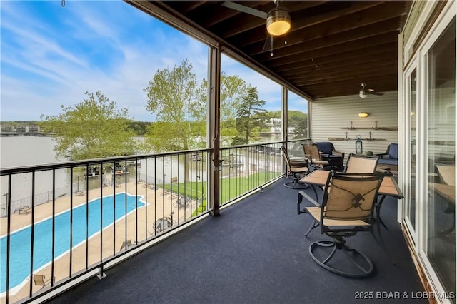 balcony featuring a ceiling fan and a water view