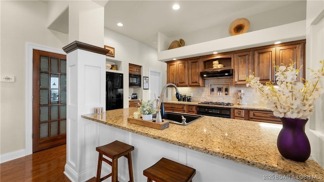 kitchen featuring a sink, open shelves, black appliances, and under cabinet range hood
