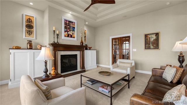 living area featuring ceiling fan, light carpet, a glass covered fireplace, recessed lighting, and baseboards