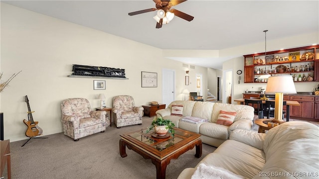 living room featuring visible vents, ceiling fan, stairway, carpet, and bar area