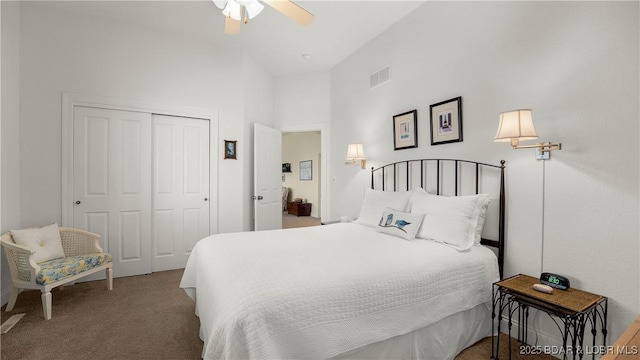carpeted bedroom with a closet, a ceiling fan, and visible vents