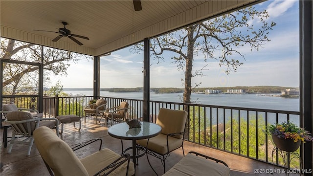 sunroom with a ceiling fan, a water view, and a wealth of natural light