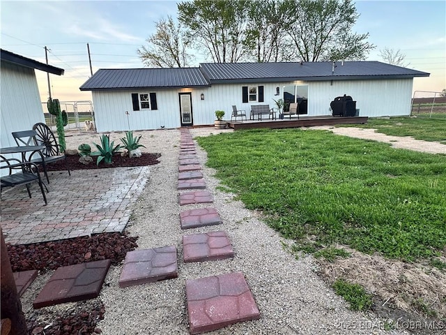 69985 US Highway 50, Tipton, MO 65081 - rear view of property featuring a wooden deck, metal roof, and a patio