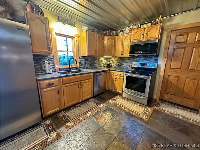 69985 US Highway 50, Tipton, MO 65081 - kitchen with stainless steel appliances, tasteful backsplash, dark countertops, and stone tile floors