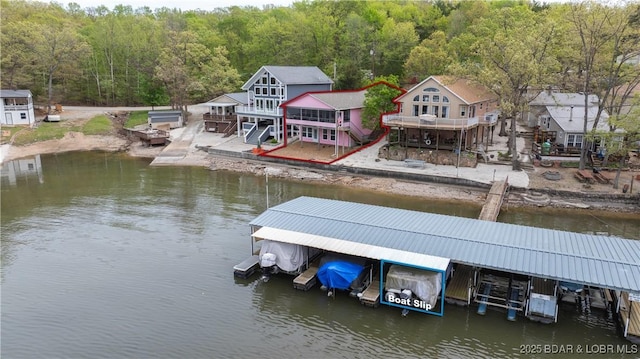 dock area featuring stairway, a deck with water view, and a forest view