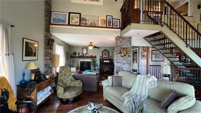 30993 Viewside Dr, Rocky Mount, MO 65072 - living area featuring wood finished floors, ceiling fan, a glass covered fireplace, stairway, and a towering ceiling