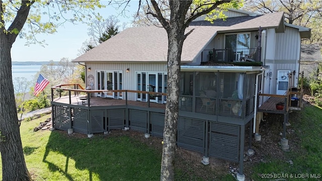 30993 Viewside Dr, Rocky Mount, MO 65072 - back of property with a sunroom, a shingled roof, a balcony, a deck with water view, and a lawn