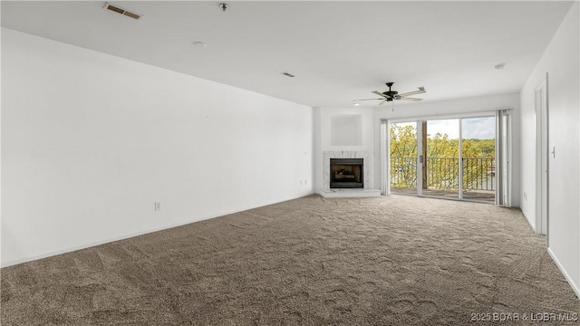 unfurnished living room featuring visible vents, ceiling fan, carpet, and a fireplace