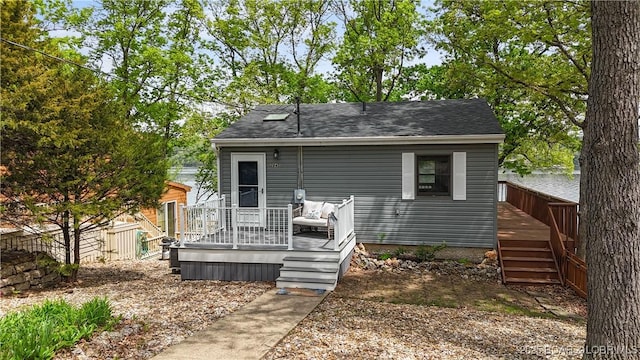 back of property with a deck and stairway