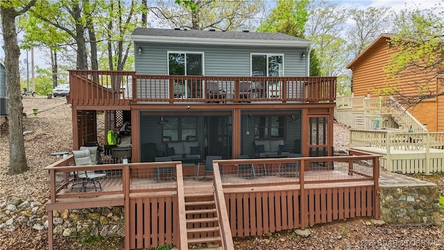 back of property with a deck, stairs, and a shingled roof