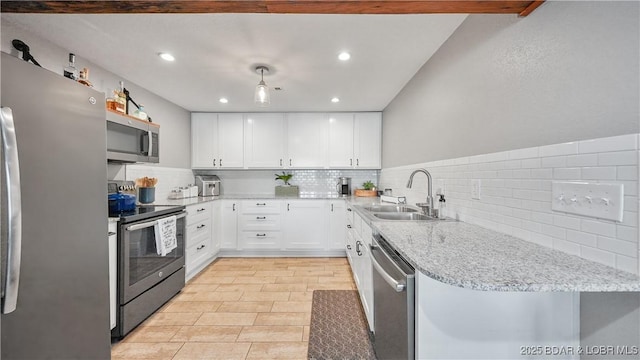 kitchen featuring light stone countertops, a sink, stainless steel appliances, backsplash, and white cabinets