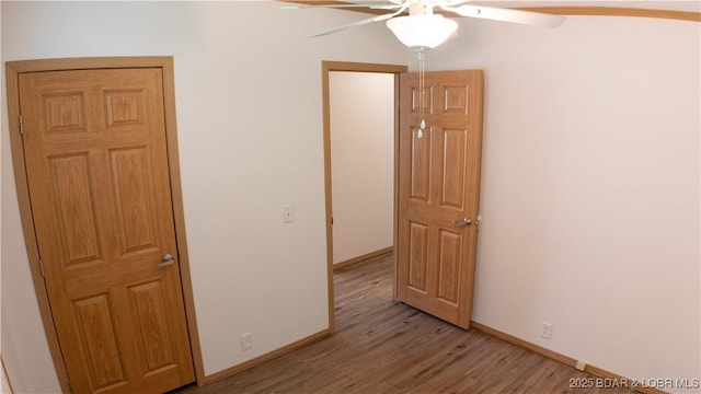 empty room featuring baseboards, ceiling fan, and light wood-style flooring