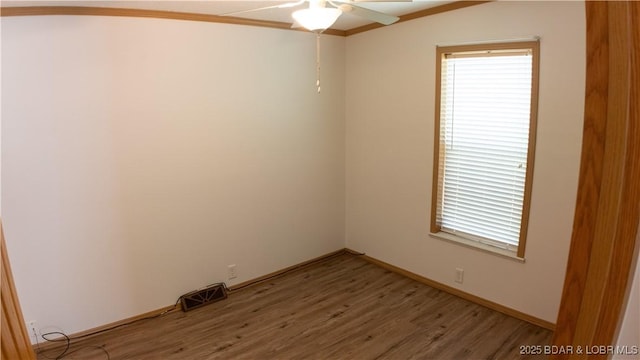 spare room with light wood-style floors, ceiling fan, a healthy amount of sunlight, and visible vents