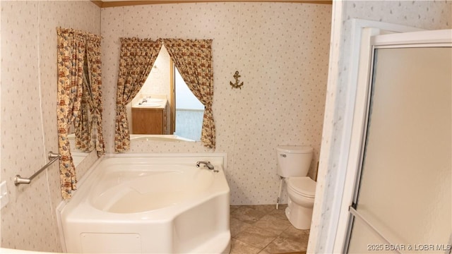 full bathroom featuring tile patterned flooring, a bath, toilet, and wallpapered walls