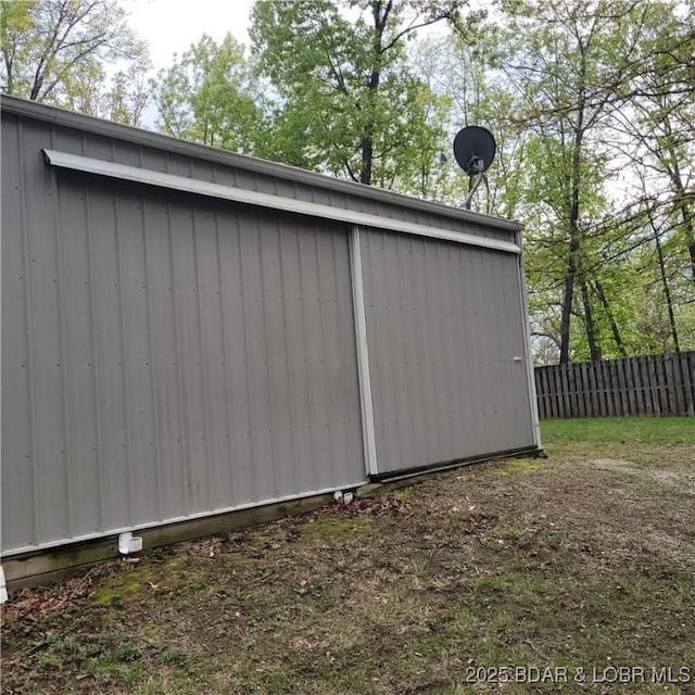 view of outbuilding with fence and an outbuilding