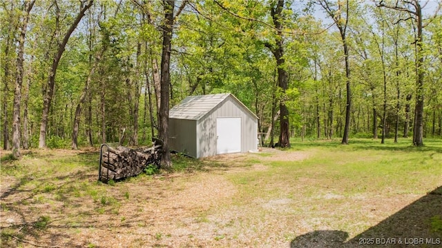 view of yard with a storage unit, an outdoor structure, and a view of trees