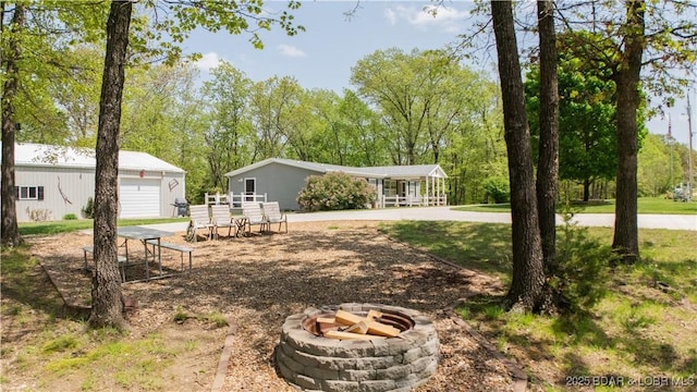 view of front of home with an outbuilding and a fire pit