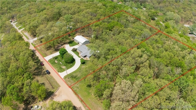 birds eye view of property with a view of trees