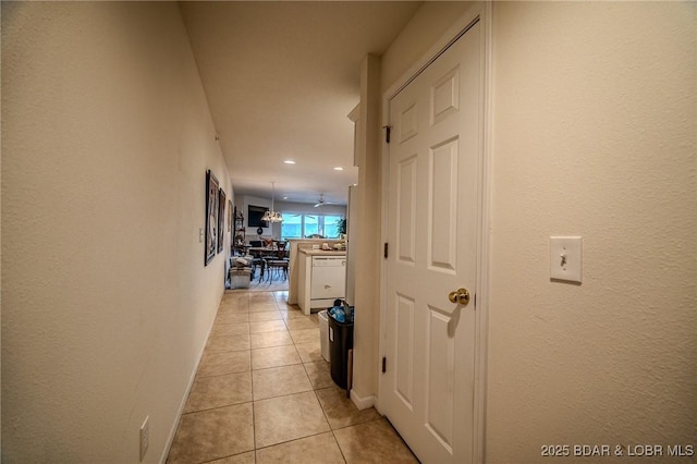 corridor featuring recessed lighting, baseboards, and light tile patterned floors